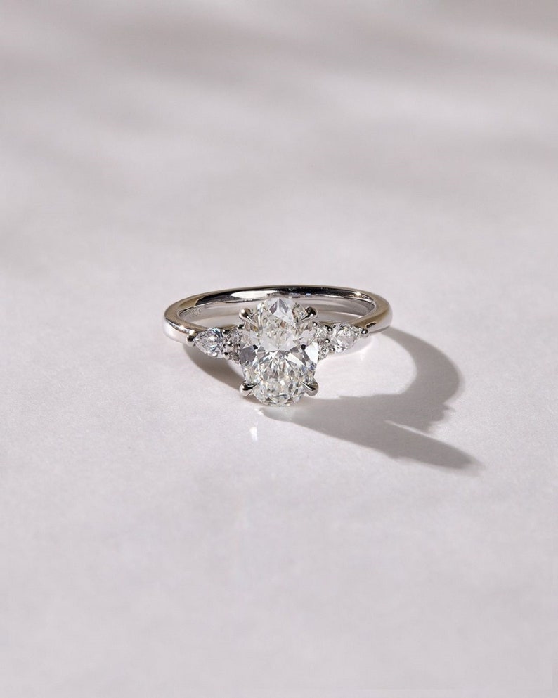 3.50ct Oval Cut Lab-Grown Diamond Cluster Engagement Ring in White Gold on Side Pear Shape Each 0.50ct.