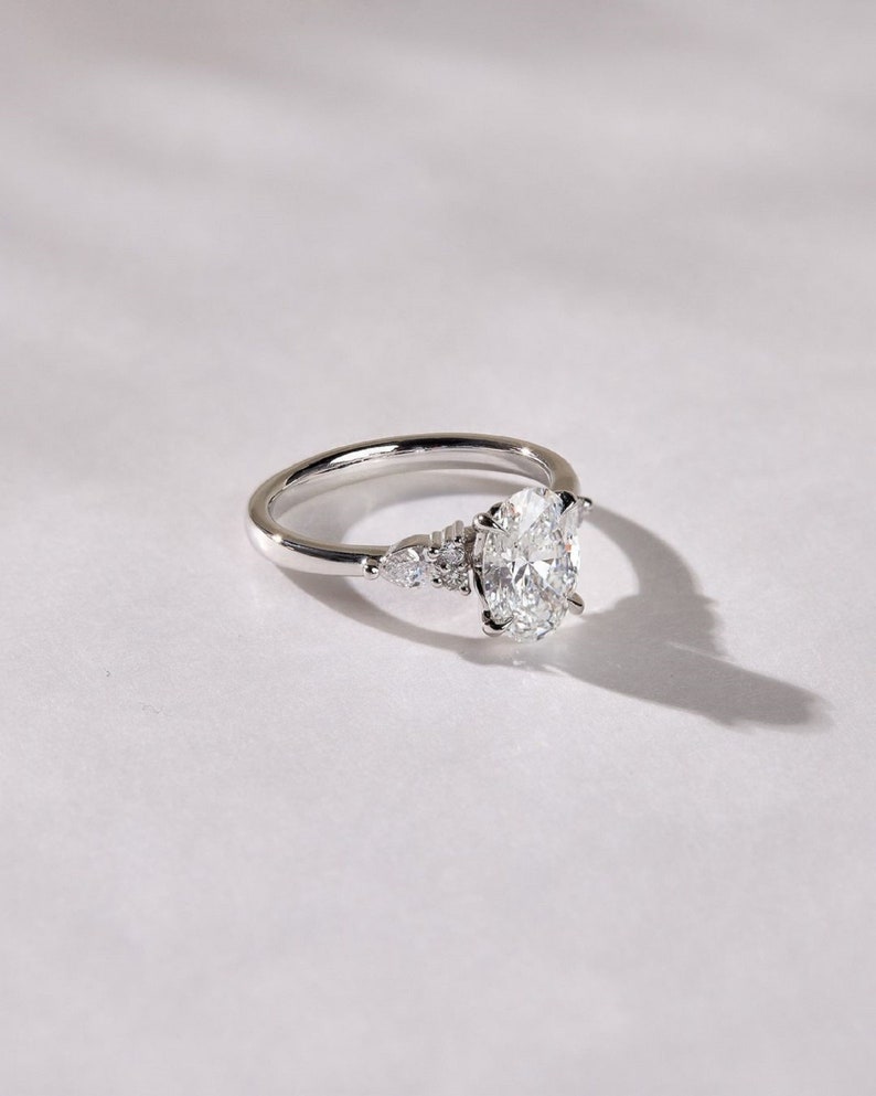 3.50ct Oval Cut Lab-Grown Diamond Cluster Engagement Ring in White Gold on Side Pear Shape Each 0.50ct.
